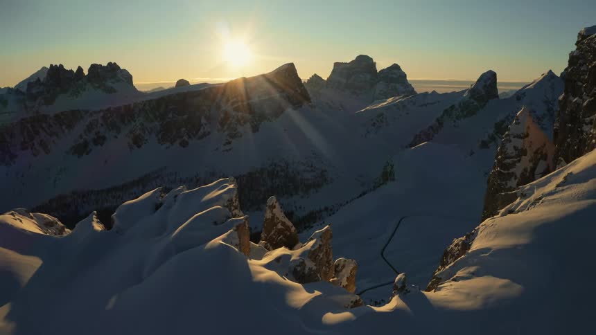 A mountain range covered in snow and ice with the sky and clouds in the background