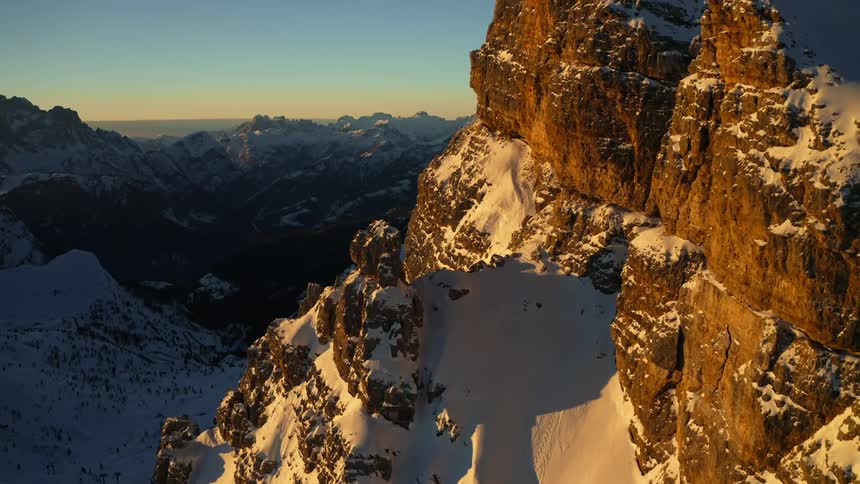The sun reflects off the snow on a mountain top