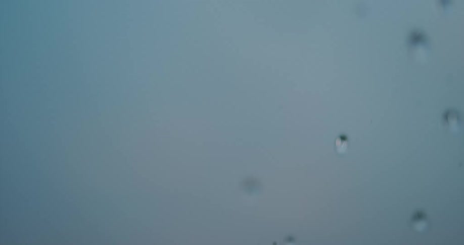 Water droplets fall against a grey backdrop