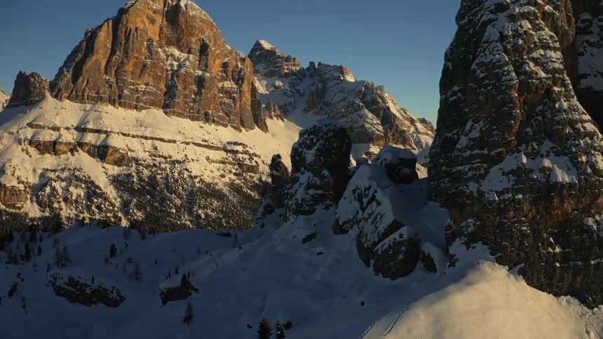 Snow covered mountains and rock formations high in a clear blue sky