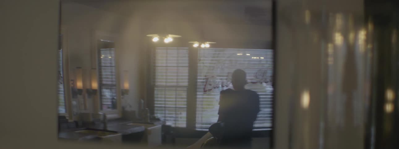 A man cuts hair in front of a window