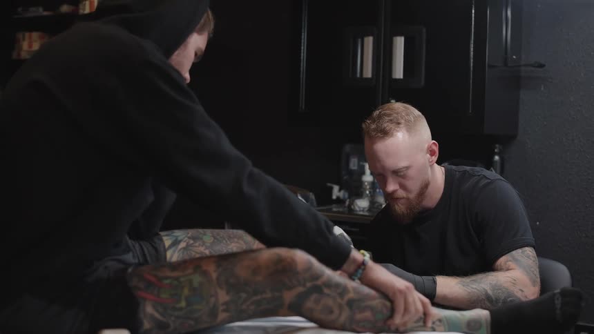 A man is receiving a tattoo in the shop