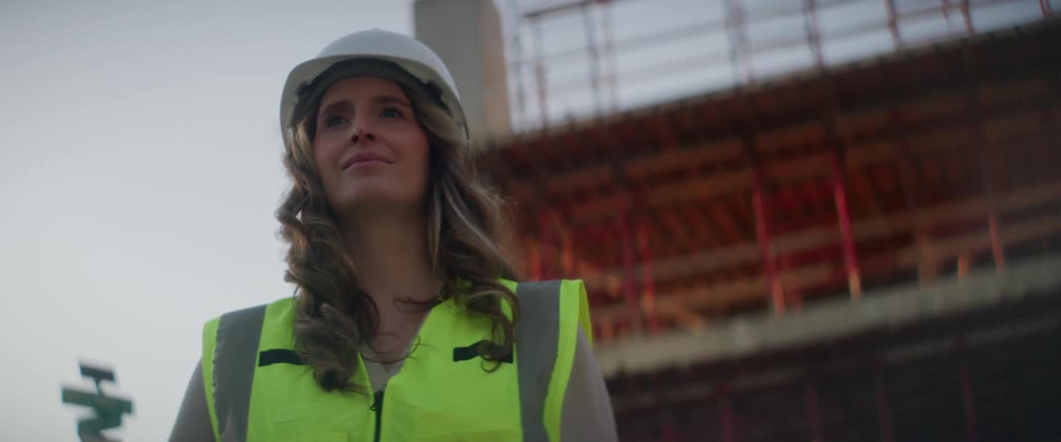 A construction worker stand in front of a building being built