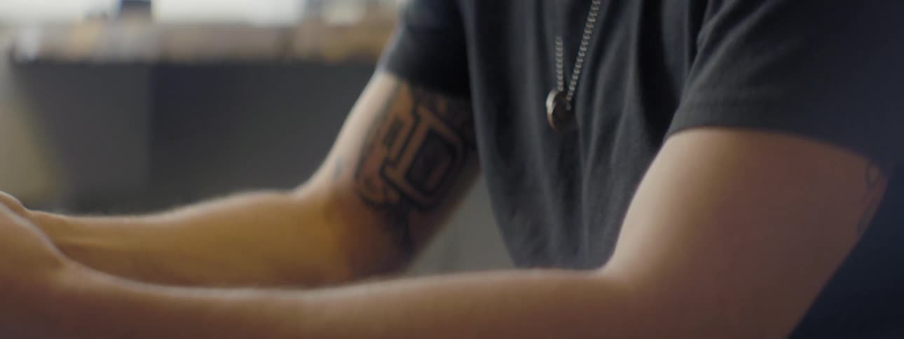 Tattooed man sitting at a table