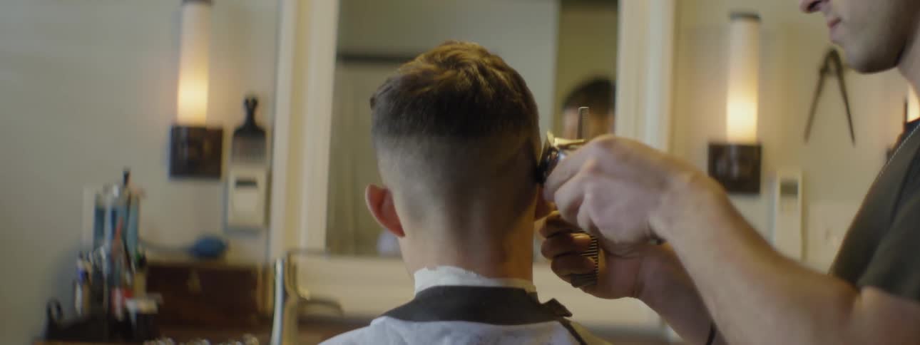 A man is getting his hair cut with a razor