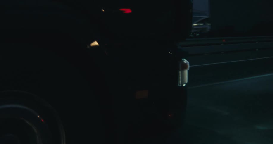 Car with its headlights on move along highway through city at night