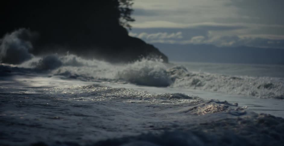Sea waves break against the beach at bay