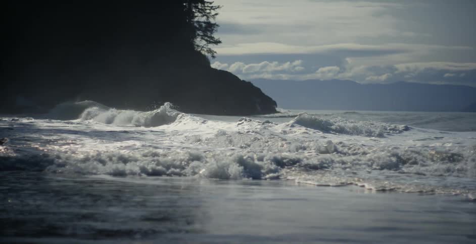 Ocean waves break against the beach at bay