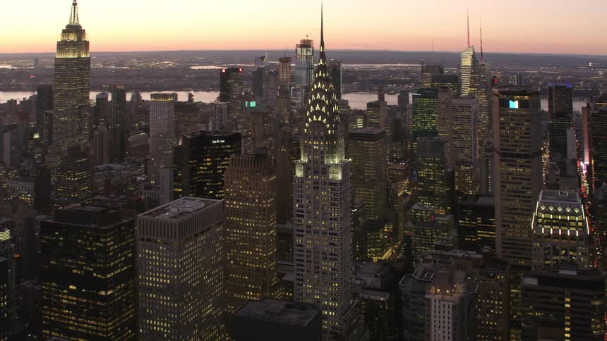 Aerial view of illuminated high rise buildings with skyscrapers at dawn