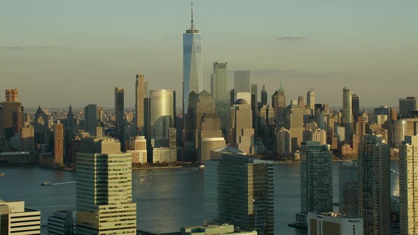 A city with buildings and skyscrapers and a river with the sky and clouds in the background