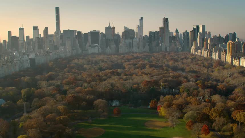 Skyscrapers surround central park under red tinted sky