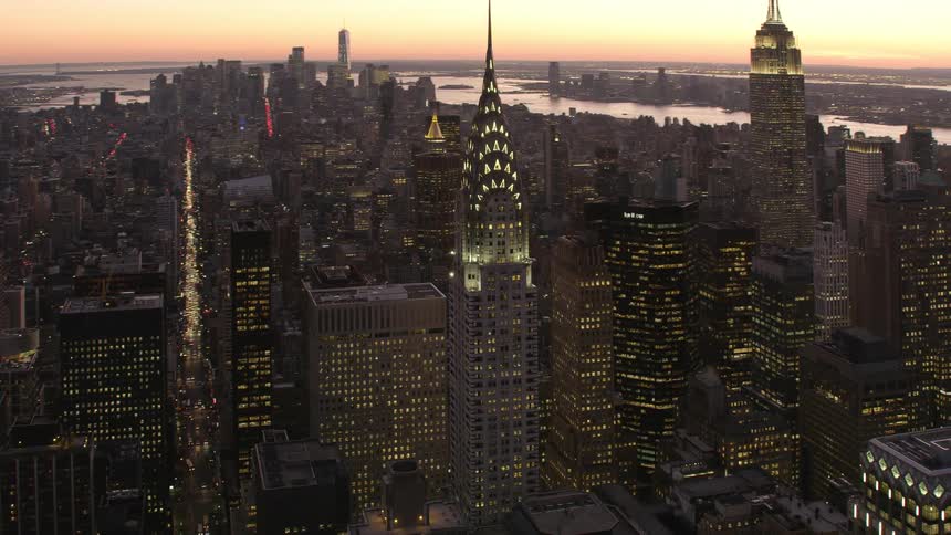 Tall skyscrapers and buildings are lit up in a big city