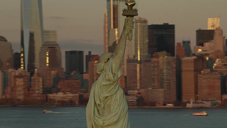 The statue of liberty stands tall against the new york city skyline