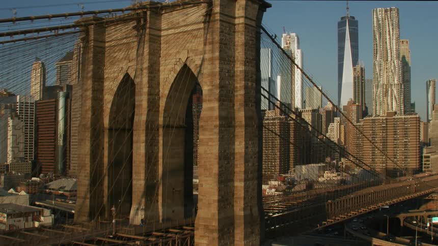 The brooklyn bridge in front of buildings and skyscrapers in new york city