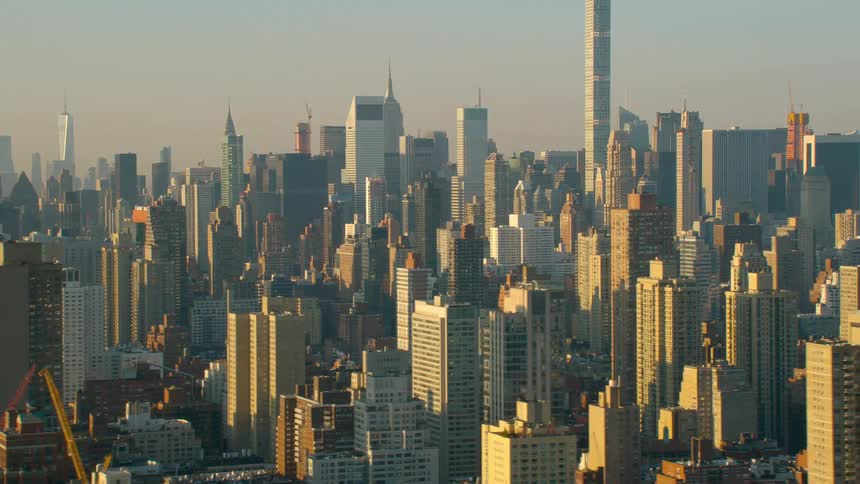 Smog obscures city downtown as sunlight brightens on side of buildings