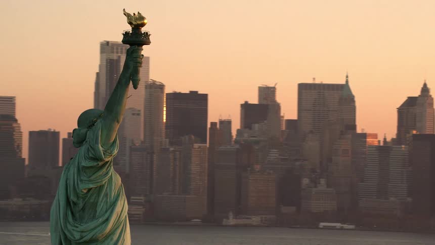 The statue of liberty in the bay of new york after sunset