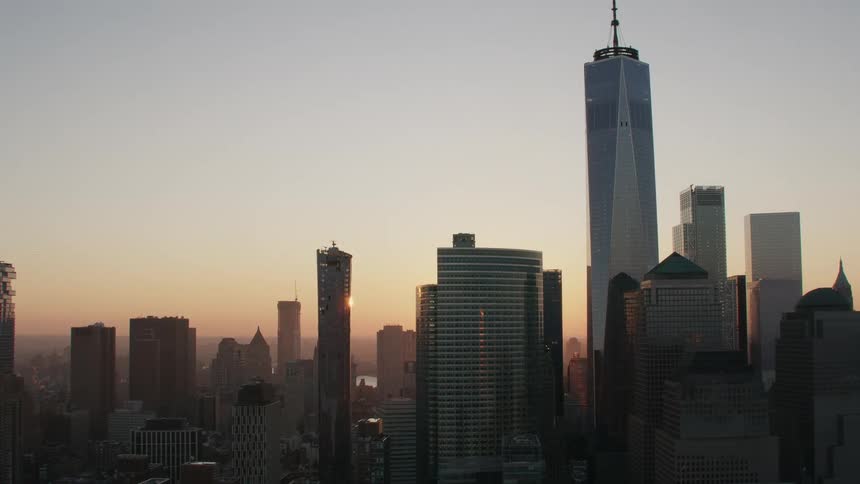 The sun is rising on a foggy morning in the city