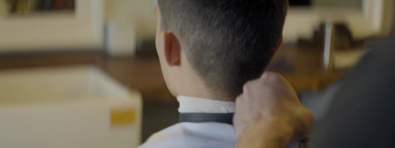 A man ties a smock around someone