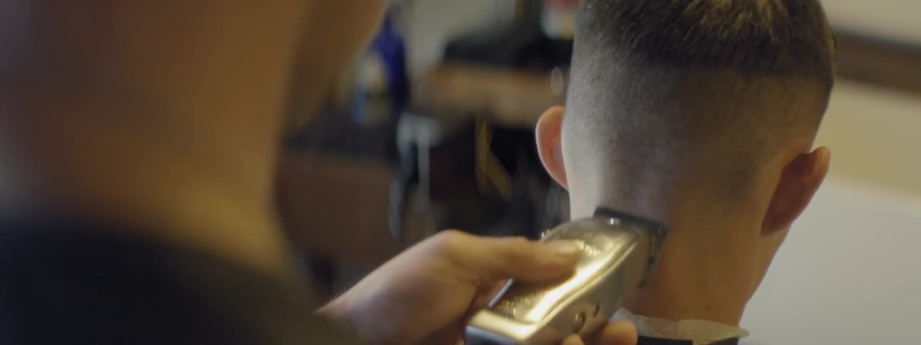 A man shaves another man's head