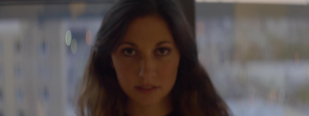 Woman looking into a camera as it moves closer to her face