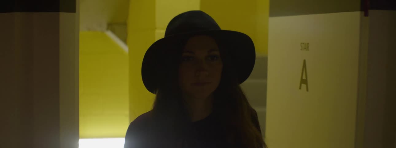 A woman opens and walks through a doorway from a stairwell