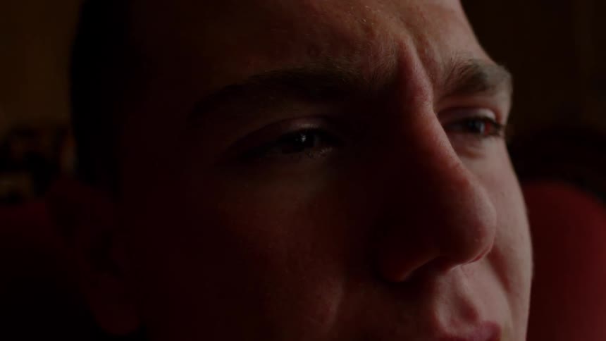 A man squints his eyes and appears as though he is about to cry