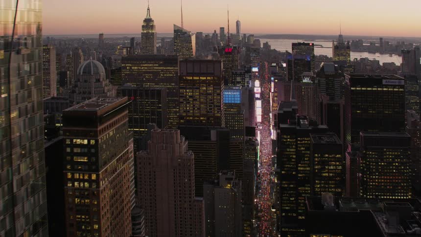 Aerial view of a big city with buildings lit up and cars traveling on the streets