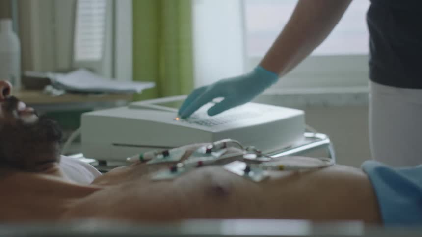 A doctor applies monitors to a patients chest