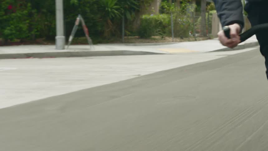 A person riding a bike on the street with trees the sky and clouds in the background
