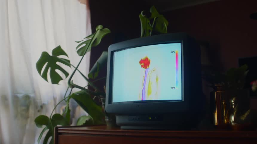 A room with a television set with a window a wall and a lamp in the background