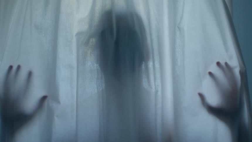A view of a person behind a curtain
