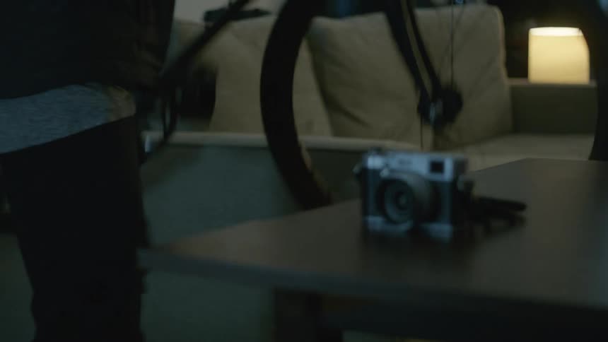 Man picks up a vintage film camera and a bicycle on his way out of home