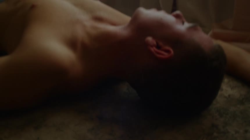 Young shirtless man laying over the carpet on the floor of a room at home