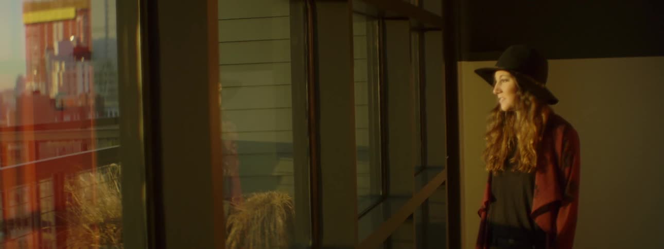 A woman smiles as she looks out of a window