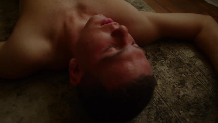 A man in a room laying on a rug
