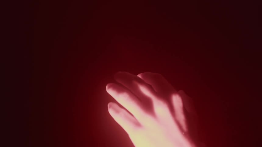 Someone is holding their hand out in front of a light and it is shining on their hand