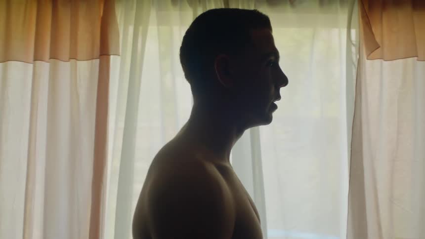 A man standing in a room in front of a window