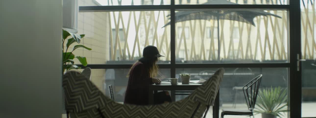 A woman sits at a table reading a book