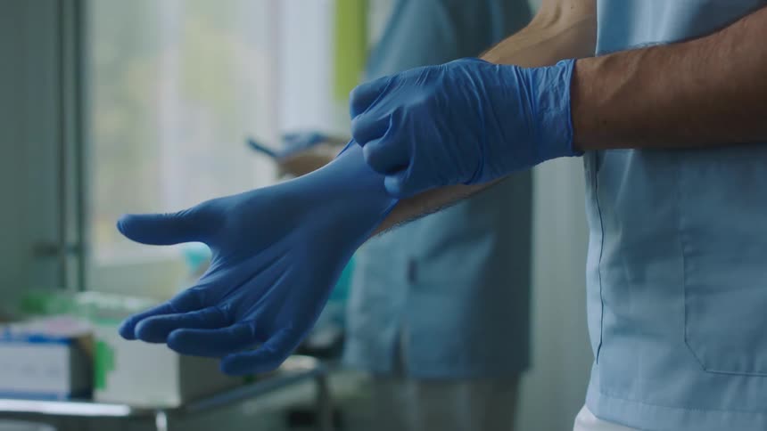 A doctor puts gloves on
