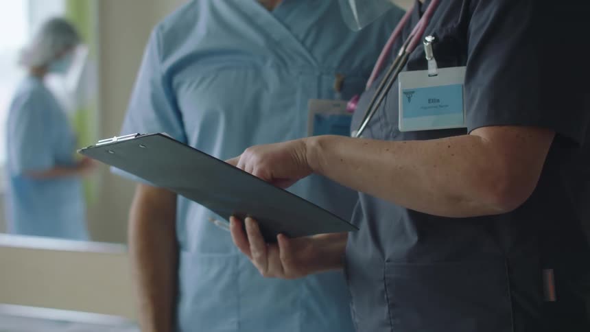 A doctor and nurse are looking at a chart in a hospital