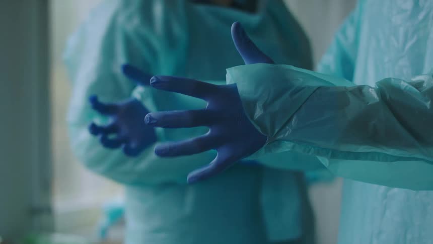 Nurses are wearing personal protective equipment in a hospital