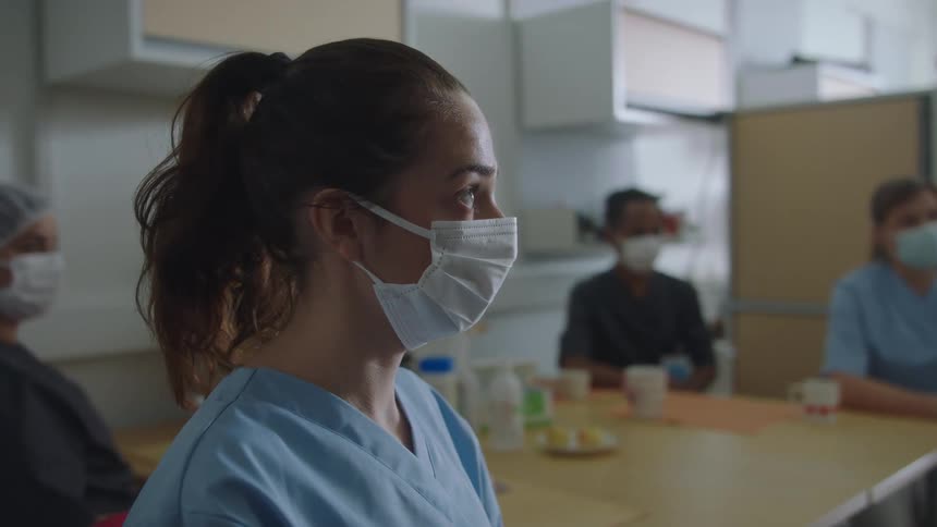Hospital staff are nodding and listening to someone in the hospital