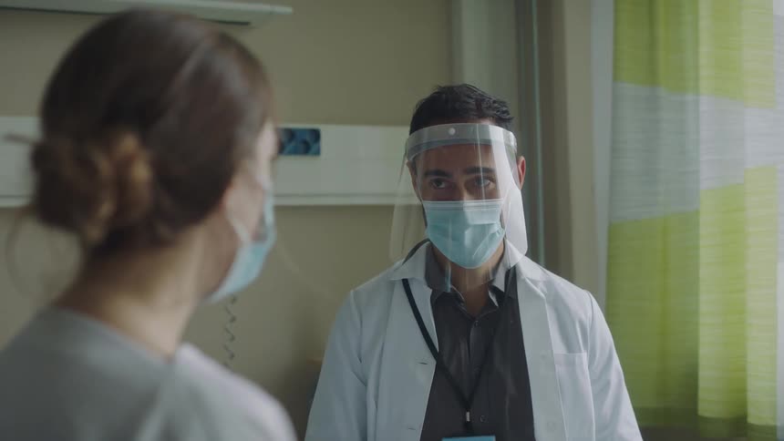 A doctor touches a patients arm to comfort her while speaking