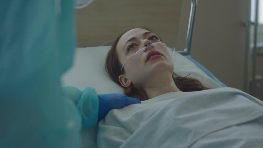 A doctor consoles a patient in the hospital bed