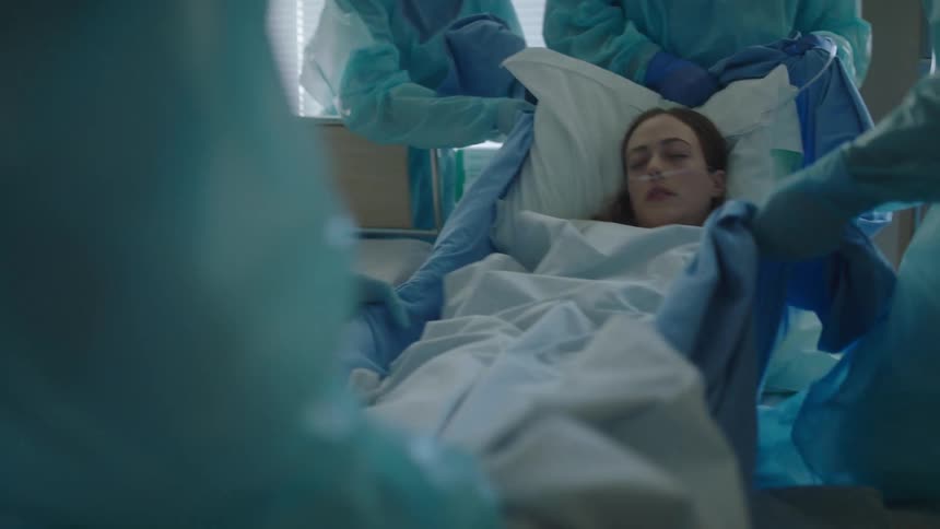A patient is lifted into a hospital bed