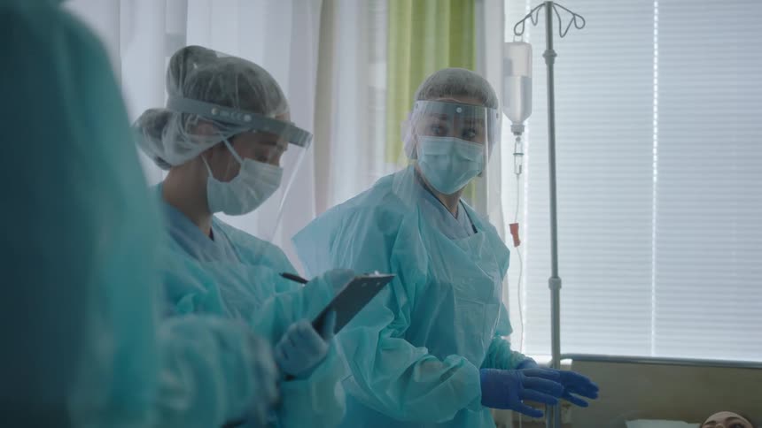 A doctor is talking to hospital staff around a patient