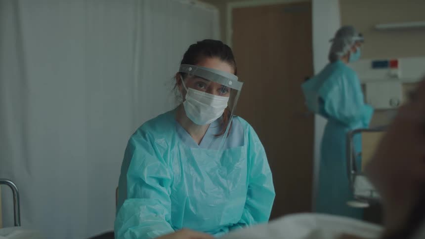 A doctor holds the hand of a patient