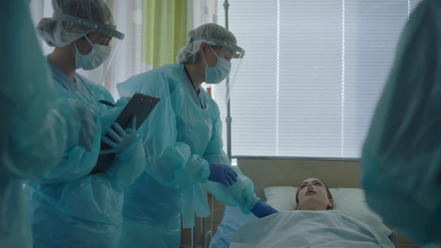 A doctor speaks with a patient and talks to colleagues
