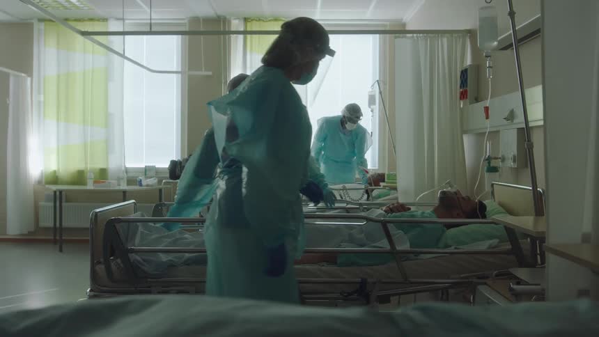Nurses attending to patients in a hospital room