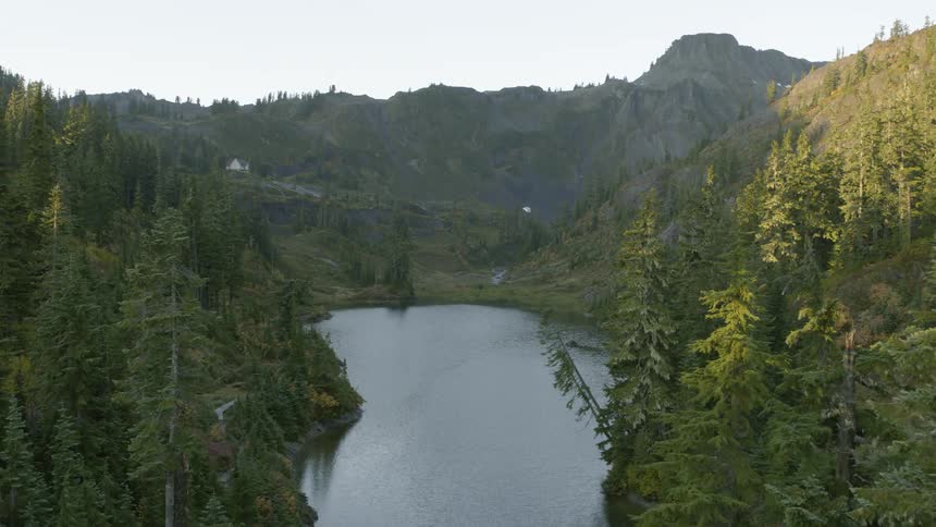 Aerial view of a small lake nested in the mountains at morning